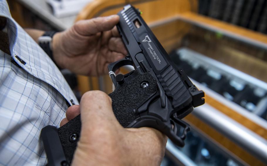 A customer checks out a hand gun that is for sale and on display at SP firearms on Thursday, June 23, 2022, in Hempstead, New York.