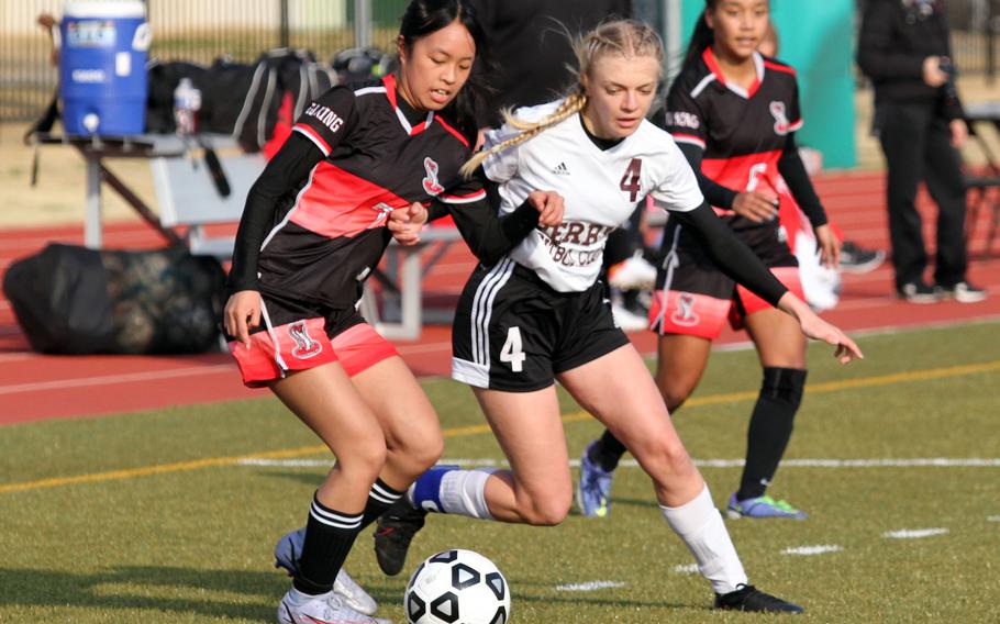 E.J. King's Kaylee Mapa and Matthew C. Perry's Cecilia Campbell tussle for the ball during Friday's DODEA-Japan girls soccer season opener at Samurai Field. The Cobras won 1-0.