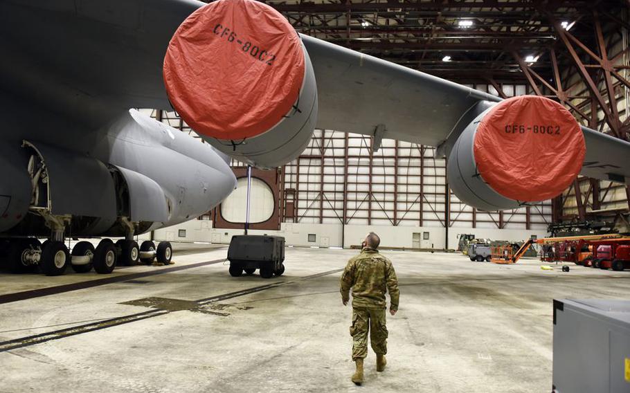 United States Air Reserve Staff Sgt. Shaun Day of Warren is dwarfed by the engines of a C-5M Super Galaxy as he works in a maintenance hangar at Westover Air Reserve Base in Chicopee, Mass.  