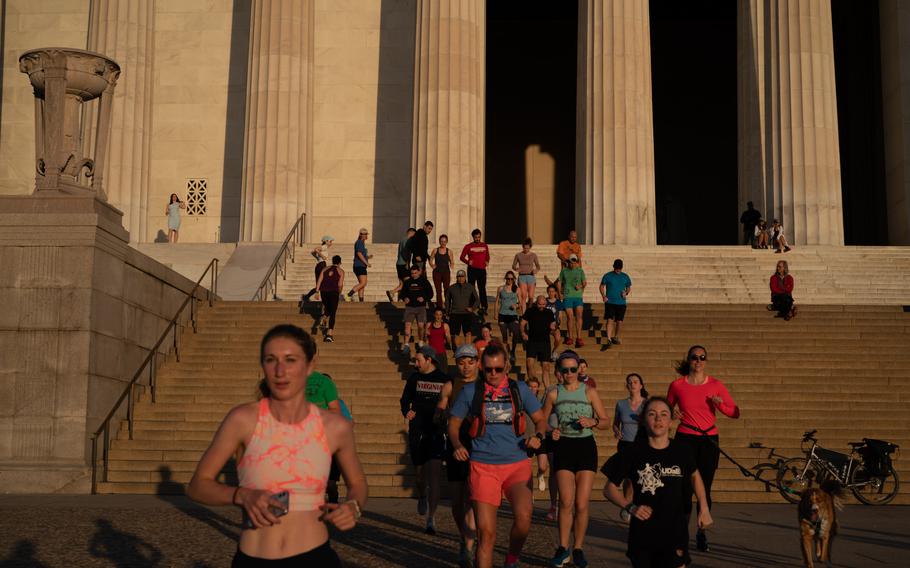 A group of runners with November Project run down the steps of the Lincoln Memorial at sunrise in Washington, D.C., on May 18, 2022. 