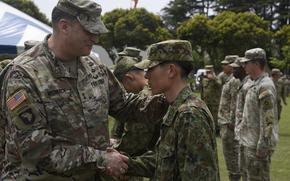 The commander of U.S. Army Japan, Maj. Gen. Dave Womack, congratulates a Japanese soldier for earning the U.S. Army Expert Soldier Badge on April 26, 2024, at Sagami General Depot, Japan. 