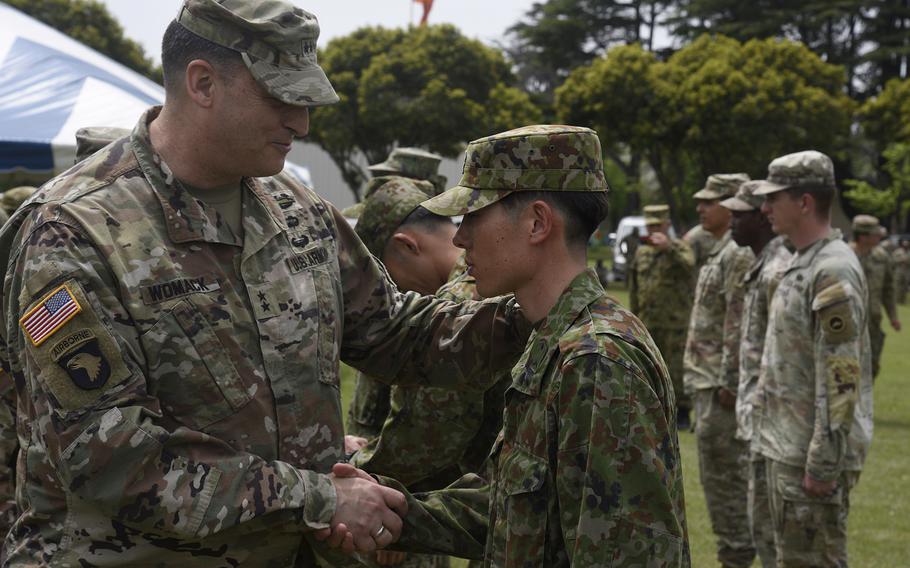 The commander of U.S. Army Japan, Maj. Gen. Dave Womack, congratulates a Japanese soldier for earning the U.S. Army Expert Soldier Badge on April 26, 2024, at Sagami General Depot, Japan. 