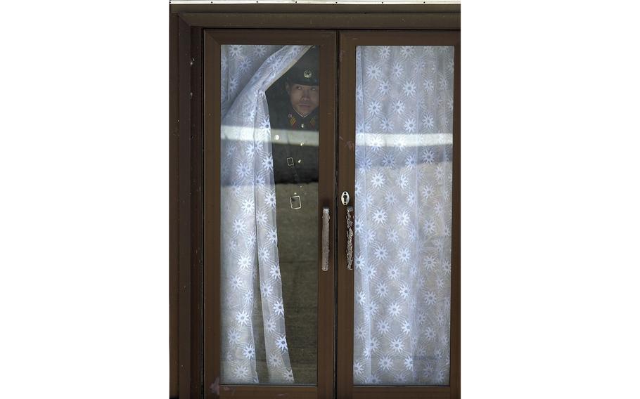 A North Korean military officer takes a peek from the North Korean recreation building