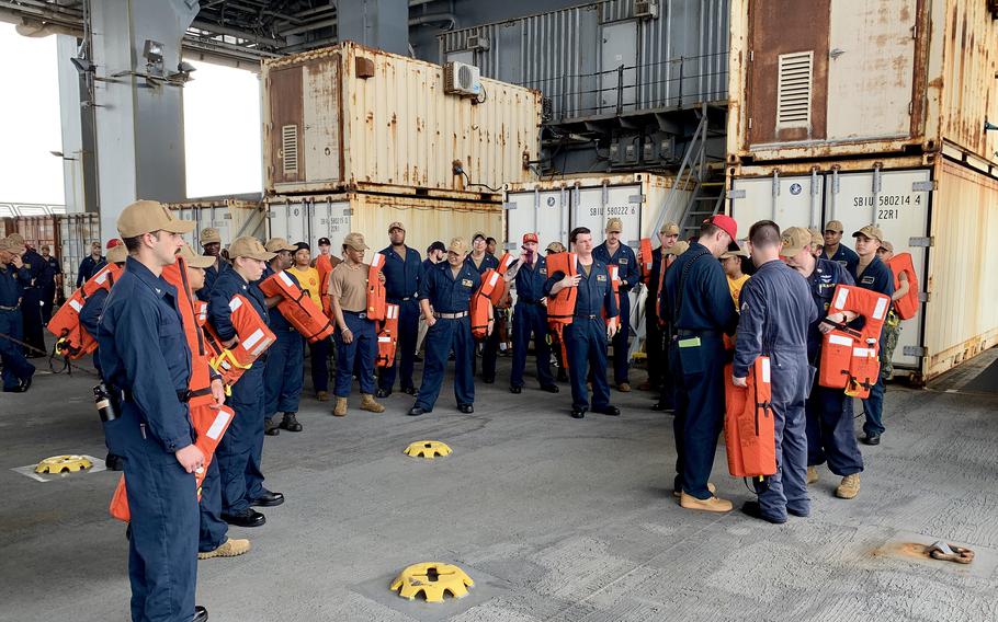 Gold crew sailors gather on the mission deck of the USS Hershel "Woody" Williams for an evacuation drill on May 3, 2024. To sustain nearly constant operations in Africa, the ship is manned by two crews, dubbed blue and gold, which rotate five-month deployments aboard the ship to keep it at sea about 10 months a year. 