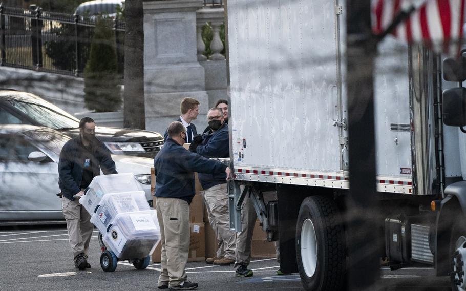 Workers load boxes of newspapers and other items into a truck inside the Eisenhower Executive Office Building on the White House complex on Jan. 14, 2021. 