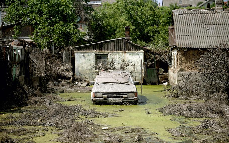This photograph taken on June 21, 2023, shows an abandoned car in Kherson in an area flooded by rising water following the collapse of the Kakhovka hydroelectric power plant dam.