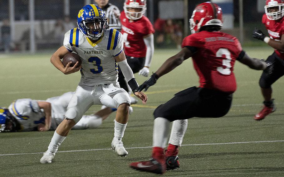 Yokota quarterback Dylan Tomas looks for running room against Nile C. Kinnick's Wendell Harrison.