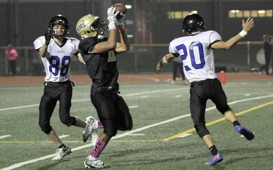 Humphreys' Manny Lawson snags a pass between Osan's Christopher Baia and Robert Jennings. Lawson caught two touchdown passes in the Blackhawks' 29-6 win Friday.