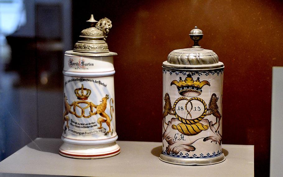 Two beer steins adorned with pretzels.