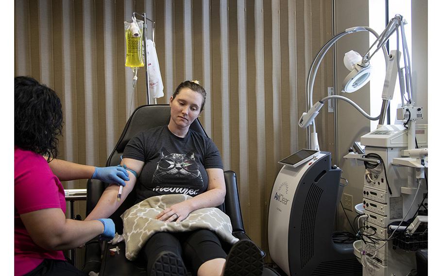 Morgan Workman gets IV therapy to help with the effects of lead poisoning from the shrapnel that remains embedded in her body, with nurse Patricia Sanchez. 