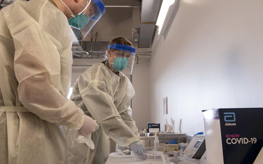 Air Force Staff Sgt. Travis Chadwick, left, and Tech. Sgt. Brooklynn Covington, both aeromedical evacuation technicians, run COVID-19 tests at Baltimore/Washington International Airport, Nov. 9, 2020. 