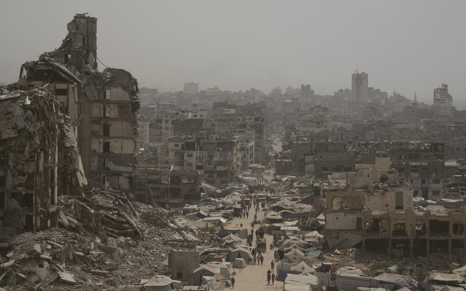 A landscape of damaged buildings with a main street going through the center of the photo.