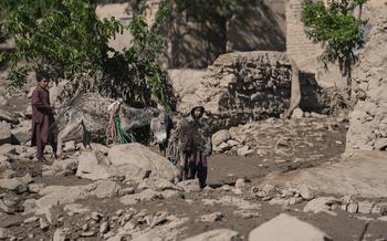 Children lead muddy donkeys through the rubble left by a flash flood that destroyed 80 homes in Chesht-e-Sharif, Herat, on May 10, 2024