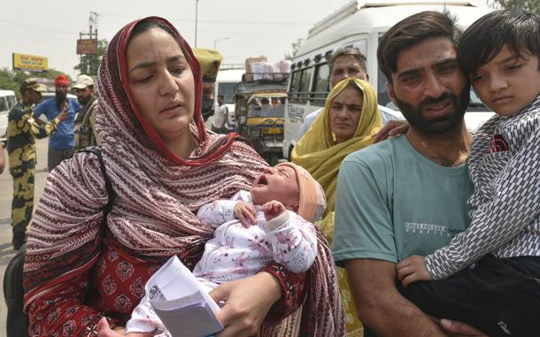 Pakistani national Sara Khan, left, married to Indian citizen Aurangzeb Khan, right, holding their children prepares to leave for Pakistan without her husband from the Attari-Wagah border between India and Pakistan, following New Delhi’s decision to order almost all Pakistani citizens to leave the country after last week’s deadly attack in Indian-controlled Kashmir, Wednesday, April 30, 2025. (AP Photo/Prabhjot Gill)