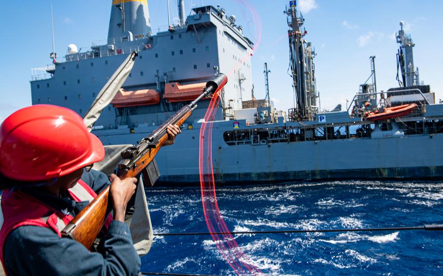 Gunner’s Mate 3rd Class Deshonda Williams from Jacksonville, Fla., fires a shot line aboard Arleigh Burke-class, guided-missile destroyer USS Milius on Nov. 28, 2022, during a replenishment-at-sea with Henry J. Kaiser-class replenishment oiler USNS Yukon while operating in the South China Sea.