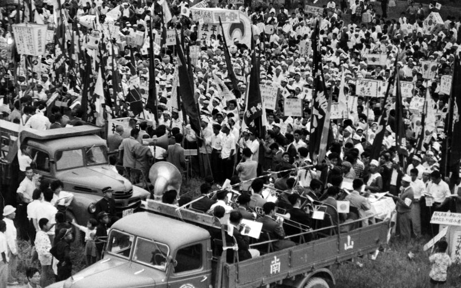 Okinawans carry signs and banners calling for “reversion to Japan” at a rally near the U.S. Civil Administration Ryukyus building in Naha, Okinawa, May 2, 1961.