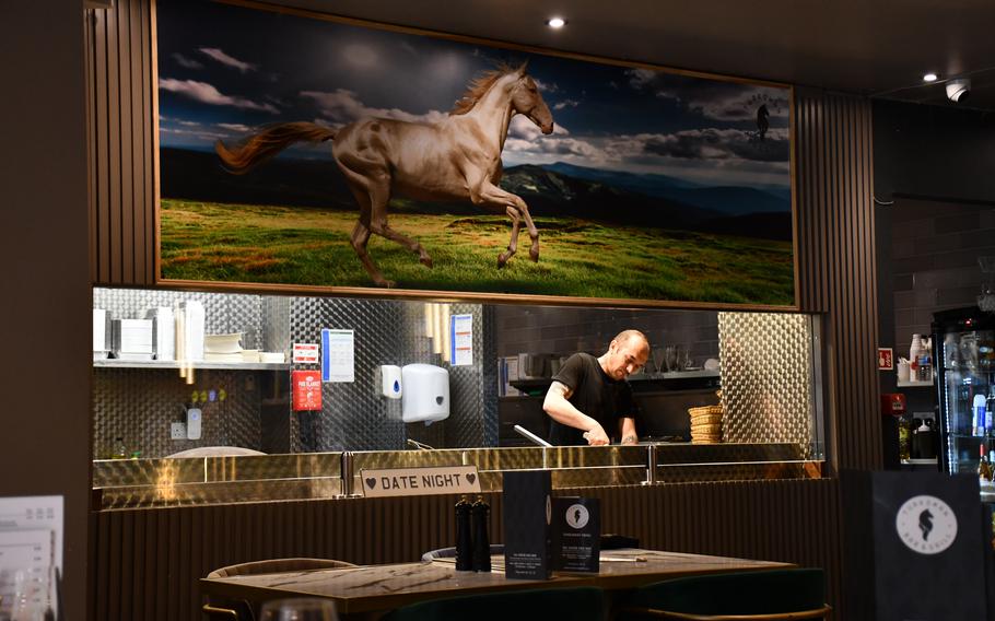 Turkoman Bar and Grill’s chef prepares meals May 9, 2023. The restaurant in Newmarket, England, has an open kitchen layout.