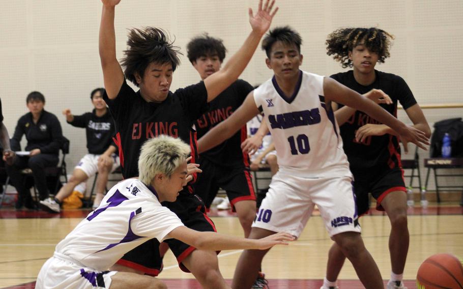 E.J. King's Shan Casimiro forces a Senri Osaka player to pass to the side during Friday's Western Japan Athletic Association boys basketball game. The Cobras won 66-39.