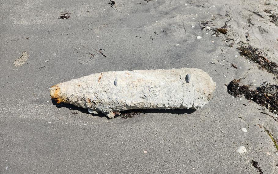 A WWII-era bomb on the sand at a beach