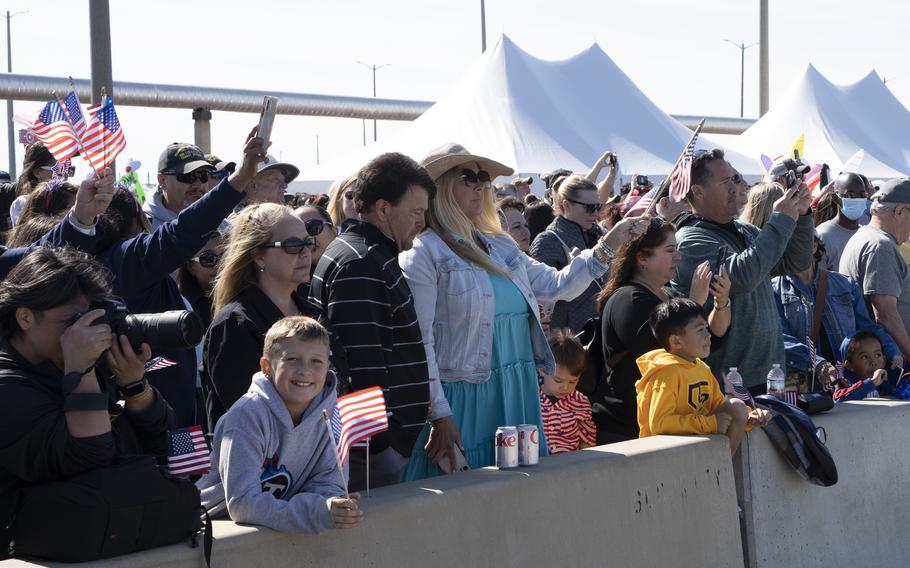 Families watch the USS George H.W. Bush as it returns to Naval Station Norfolk, Sunday, April 23, 2023. 