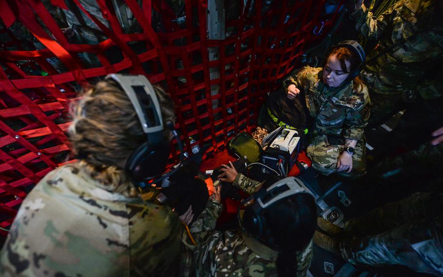 Air Force Capt. Samantha Stilwell, 86th Aeromedical Evacuation Squadron medical crew director, right, watches as Army medical technicians demonstrate how to secure an airway and life support equipment on a military working dog mannequin June 6, 2023. Army and Air Force teams participated in a joint a medical evacuation flight from Ramstein Air Base, Germany, to Mihail Kogalniceanu Air Base, Romania, and back.