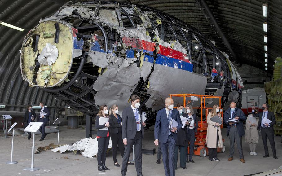 Judges and lawyers view the reconstructed wreckage of Malaysia Airlines Flight MH17, at the Gilze-Rijen military Airbase, southern Netherlands, on May 26, 2021.
