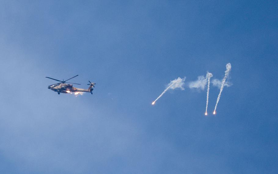 An Israeli Apache helicopter releases flares while patrolling over the Israel-Gaza border on Oct. 11, 2023.