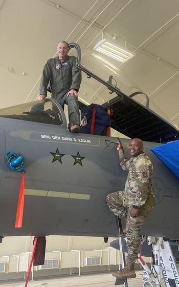 Brig. Gen. David Eaglin, left, and Command Chief Master Sgt. Ronnie J. Woods pose for a final shot on an F-15 Eagle before it departs Kadena Air Base, Okinawa, Dec. 1, 2022.