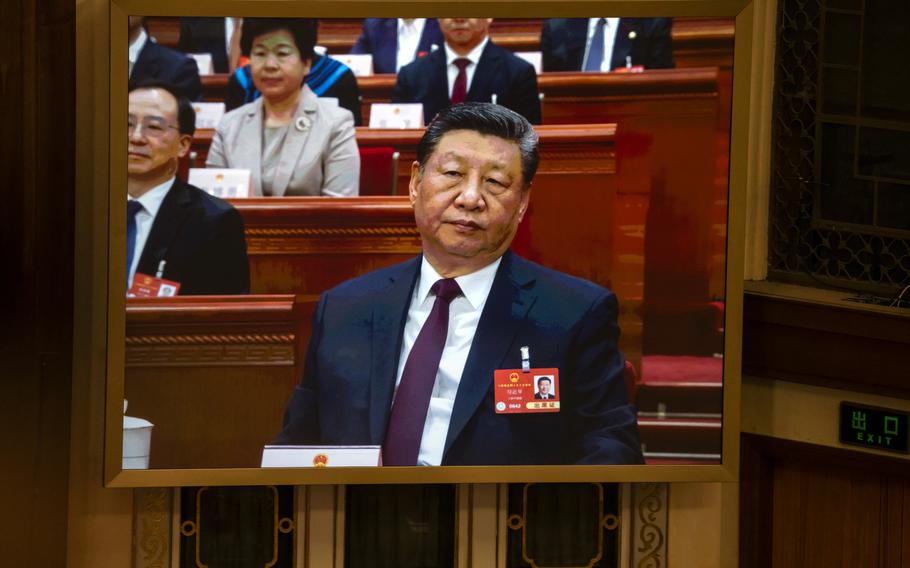 President Xi Jinping sitting and listening to a speaker.