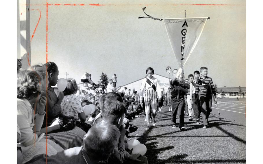 Tachikawa Air Base, Japan, Oct. 22, 1960: Standard of Athens leads Junior Olympic paraders at Tachi West Track at Tachikawa Air Base, Japan, Saturday, Oct. 22, 1960. Behind these athletes are competitors from teams named for Argos, Corinth, Thebes, Sparta and other ancient Greek cities.