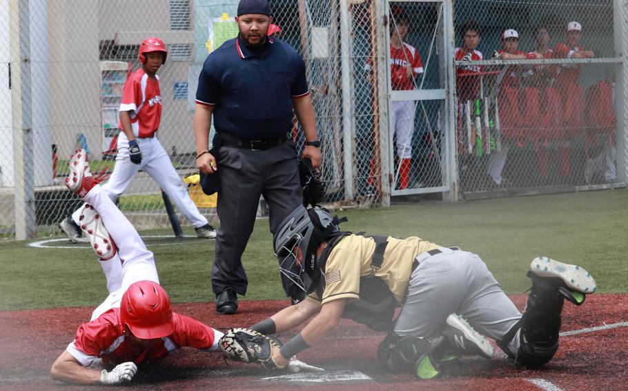 Kinnick's Jonathan Fitzgerald tries to slide in through the tag of Hunmphreys' Bradley Miller during Tuesday's Division I baseball playoff game. The Red Devils won 7-2; they'll play for third place on Thursday.