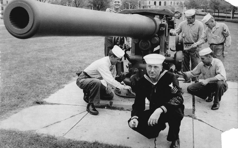 Sailors apply a fresh coat of paint to a gun