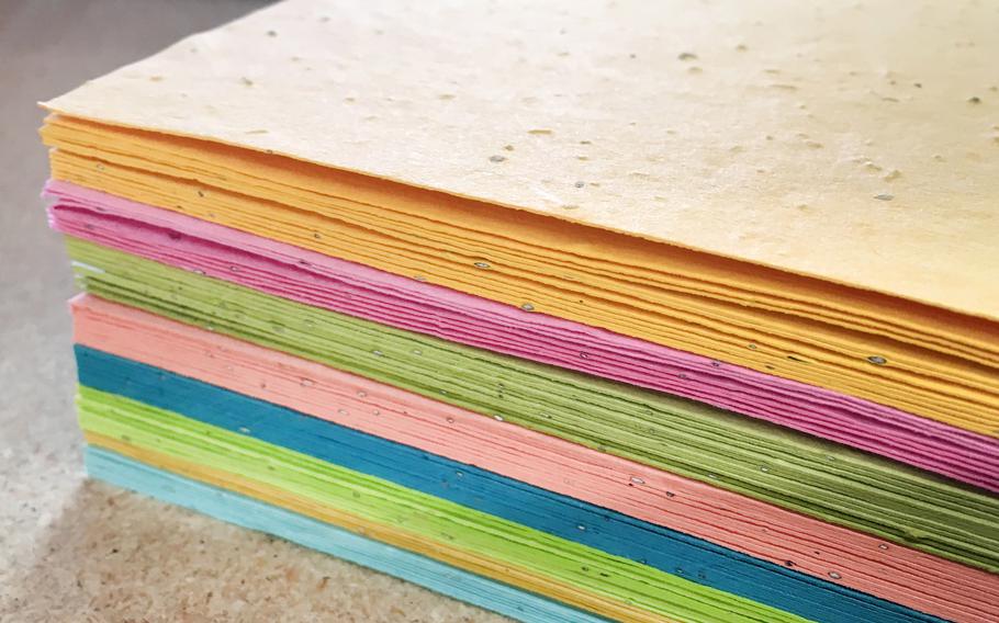 A stack of colored plantable seed paper sheets from Botanical PaperWorks.