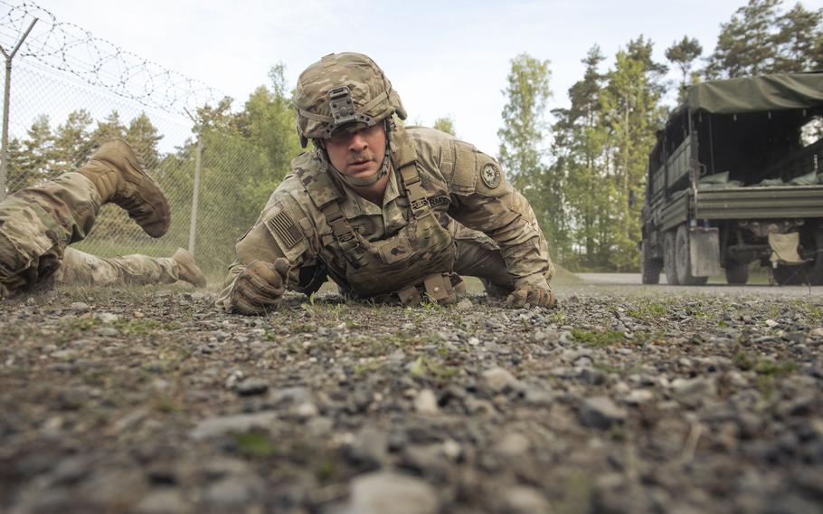 A ground-level shot of a soldier low-crawling.