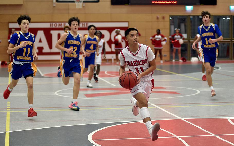 Kaiserslautern's Jayden Dayao goes up for a layup during the Raiders' home game against Wiesbaden on Friday evening at Kaiserslautern High School in Kaiserslautern, Germany. Trailing, from left, are the Warriors' Gavin DeLuca, Teagan McConville and Collin Koschnik.