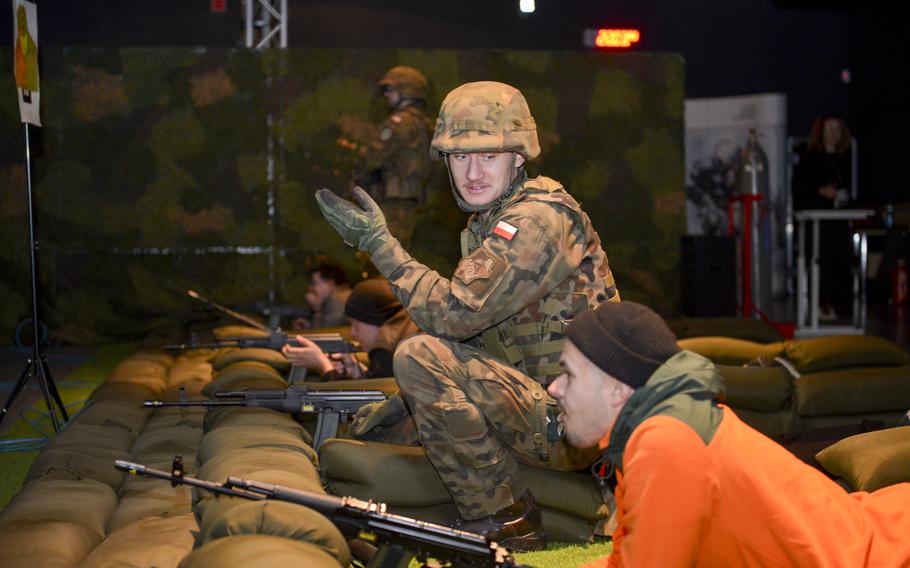 A Polish soldier gives shooting tips to a civilian trying out a laser rifle training course as part of a familiarization course at the Military University of Technology in Warsaw, Poland, on Nov. 5, 2022. 