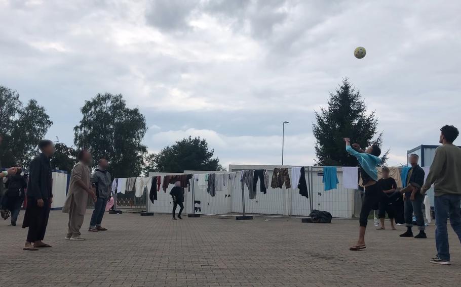 Afghan men play volleyball without a net in a concrete courtyard at Rhine Ordnance Barracks in Kaiserslautern, Germany, Aug. 30, 2021. The Army installation is housing more than 3,000 Afghan evacuees before they are resettled in the U.S. 