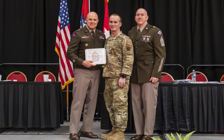 Maj. Gen. Jonathan M. Stubbs, the adjutant general of the Arkansas National Guard, and Command Sgt. Maj. Gregory White, senior enlisted leader of the Arkansas National Guard, present the Vanguard Award to Master Sgt. Greggorey Brewer at the Enlisted Association of Arkansas National Guard and the National Guard Association of Arkansas (AANG/NGAA) Joint State conference Saturday, Feb. 24, 2024, to acknowledge his acts of heroism following a car crash in Sebastian County in June 2023.