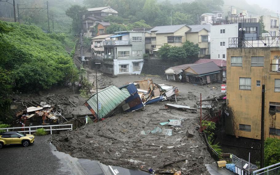 Houses are damaged by mudslide following heavy rain at Izusan district in Atami, west of Tokyo, Saturday, July 3, 2021. 