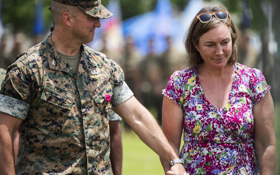 Col. Lance Lewis, outgoing commander of Marine Corps Air Station Iwakuni, Japan, accompanies his wife, Wendy Lewis, to their seats during the ceremony on June 16, 2022. 