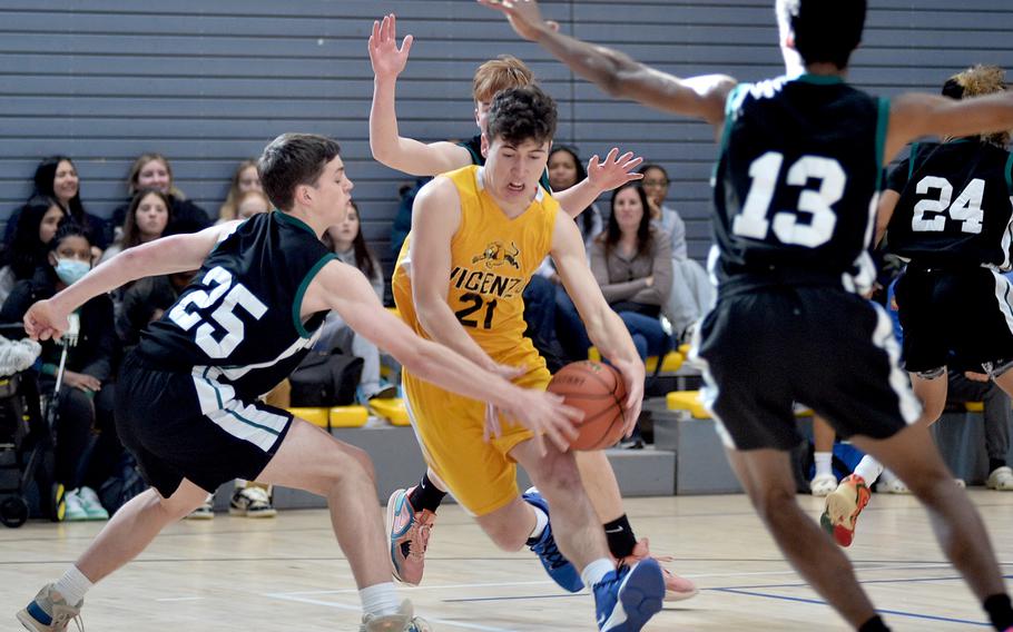 Vicenza’s Jayden Steimle tries to drive through Naples’ Patrick Fraim, left, and Chris White during the final game of pool play of the Division II DODEA European Basketball Championships at Southside Fitness Center on Ramstein Air Base, Germany. The Wildcats won 61-21.