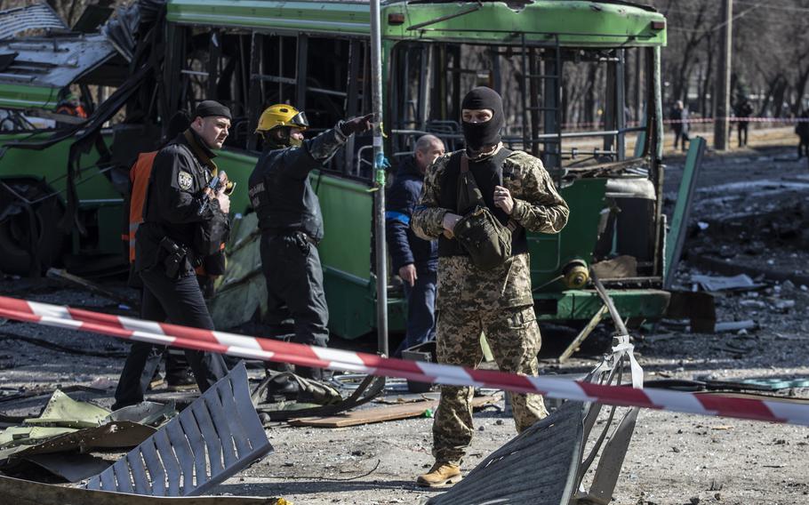 A Ukrainian soldier stands by a destroyed trolley car in Kyiv on March 14. 