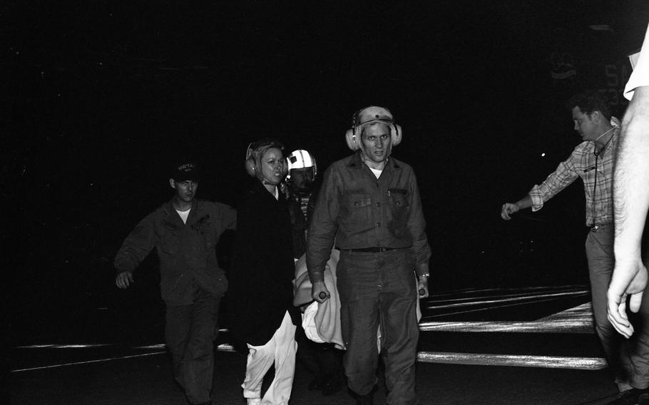 Corpsmen carry a victim on a stretcher.