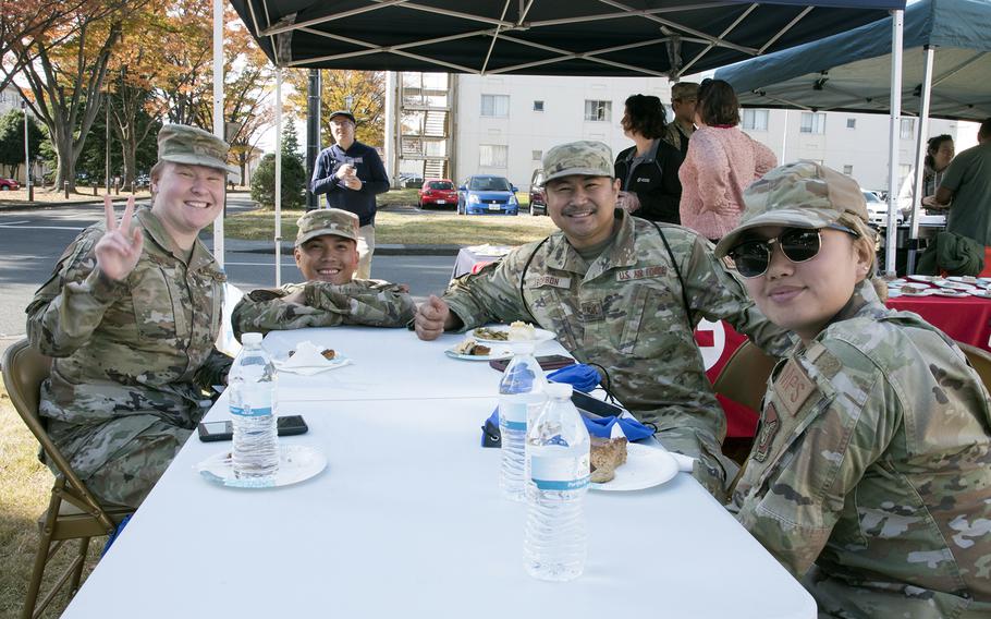 Unaccompanied service members pose during a Thanksgiving meal provided by the USO at Yokota Air Base, Japan, Tuesday, Nov. 22, 2022.