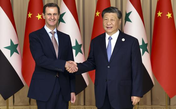 In this photo released by Xinhua News Agency, Chinese President Xi Jinping, right, shakes hands with Syrian President Bashar Assad before their bilateral meeting in Hangzhou, China, Friday, Sept. 22, 2023.