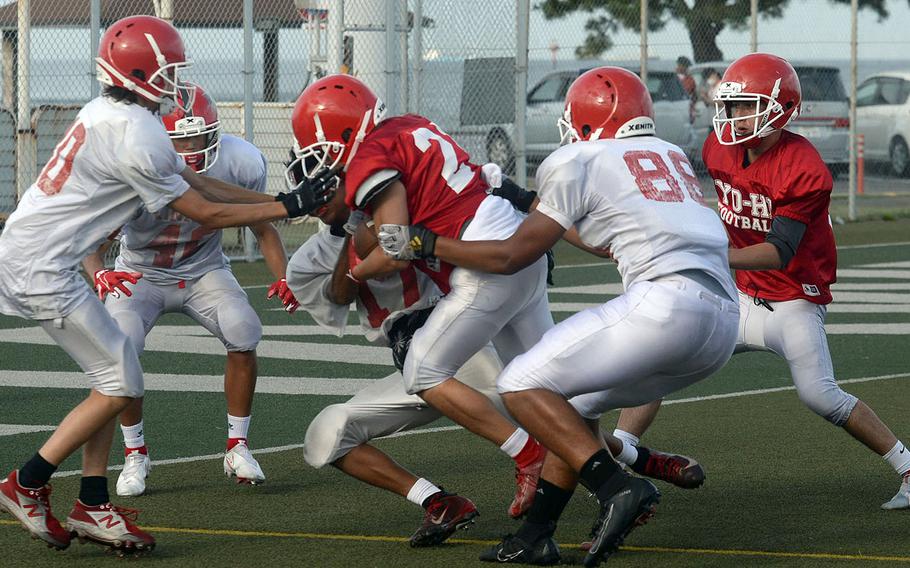 Nile C. Kinnick junior running back Brandon Euceda bulls through teammates during Tuesday's practice.