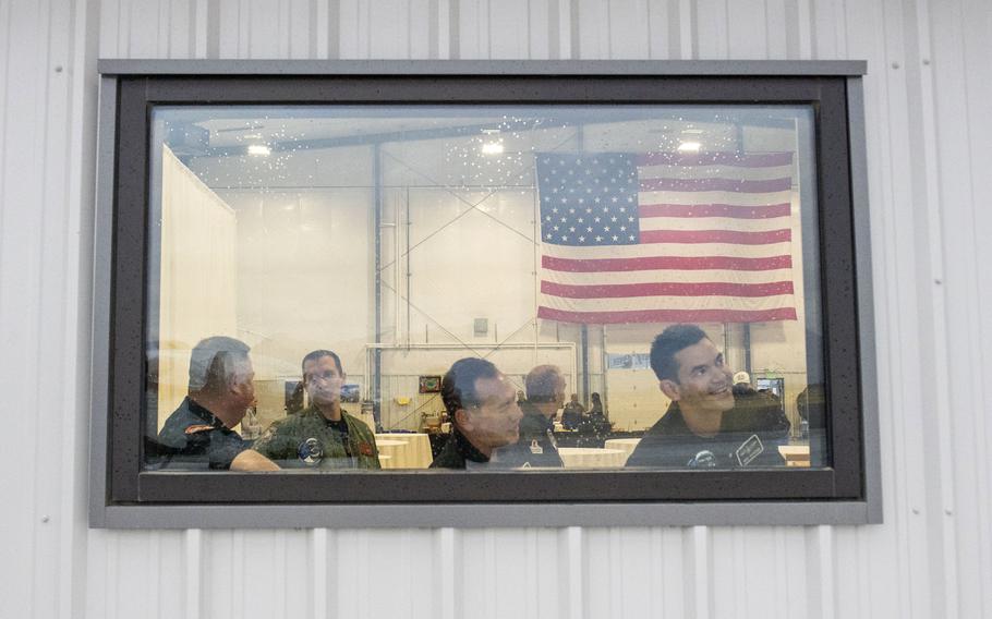Jared Isaacman, right, watches from the hangar as mission commander Todd Ericson takes flight in the MiG. The idea is to get "comfortable with being uncomfortable," Isaacman says. 