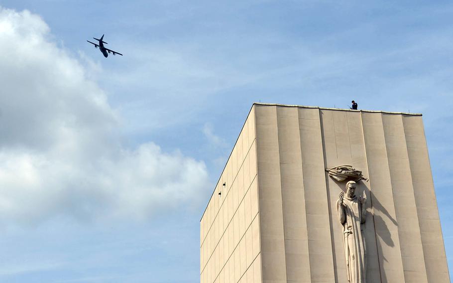 A C-130 from the 86th Airlift Wing out of Ramstein Air Base, Germany, flies over the memorial chapel at Lorraine American Cemetery in St. Avold, France, during a 2019 Memorial Day ceremony. U.S. military planes will perform flyovers at ceremonies in Europe streamed online this year. 