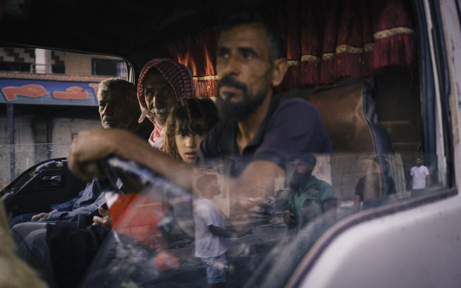 A family seated in the front of a truck.