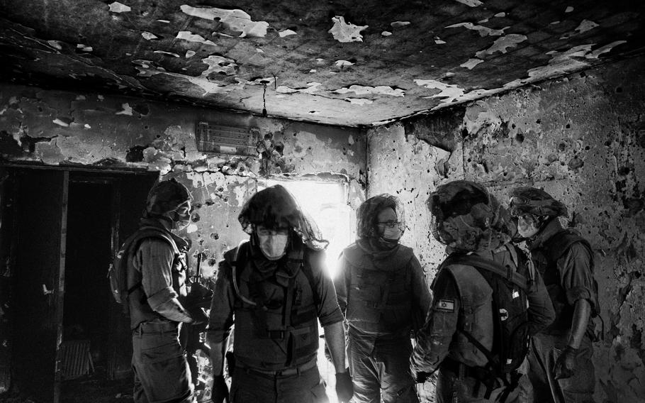 Israel Defense Forces soldiers survey a damaged house in the Israeli village of Kfar Aza on Oct. 10, 2023. 